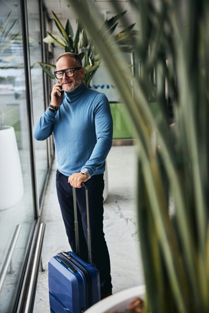 Business man talking on the mobile phone by the window to expand business into Australia